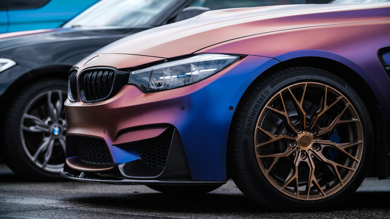 A BMW M3 F80 wrapped in chameleon vinyl wrap, equipped with custom wide body kit, carbon fiber parts, forged wheels and low profile race tires.