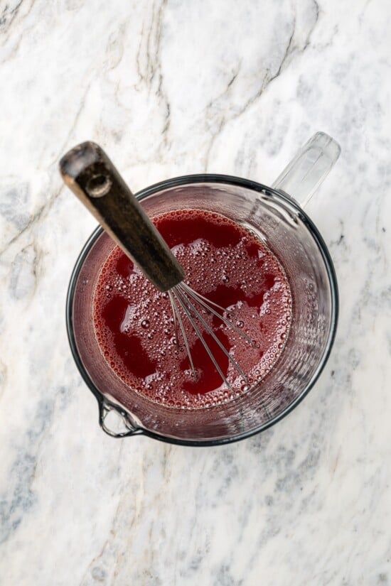 This Slow Cooker Coq au Vin is easier and lighter than the traditional version, but just as delicious with smoky bacon, mushrooms and onions. Whisking wine sauce in liquid measuring cup.