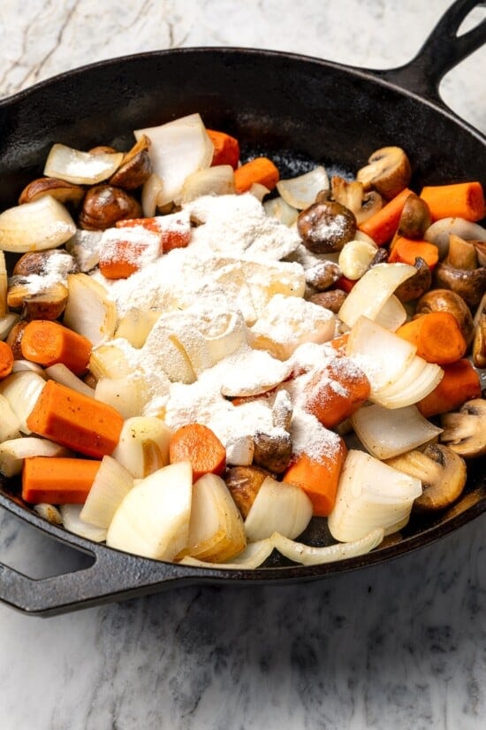 This Slow Cooker Coq au Vin is easier and lighter than the traditional version, but just as delicious with smoky bacon, mushrooms and onions. Flour sprinkled over vegetables in skillet.