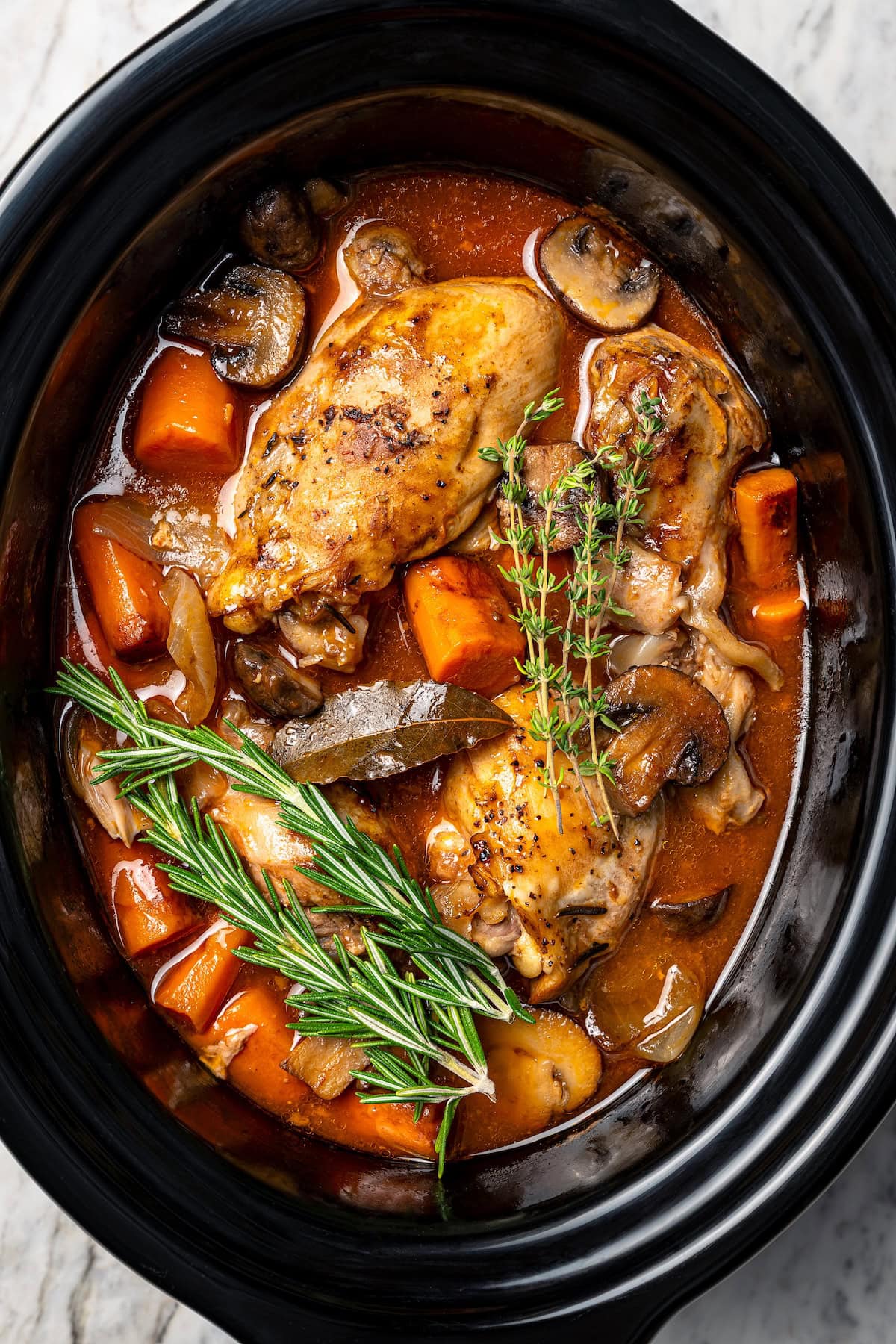 This Slow Cooker Coq au Vin is easier and lighter than the traditional version, but just as delicious with smoky bacon, mushrooms and onions. Healthy coq au vin in slow cooker.