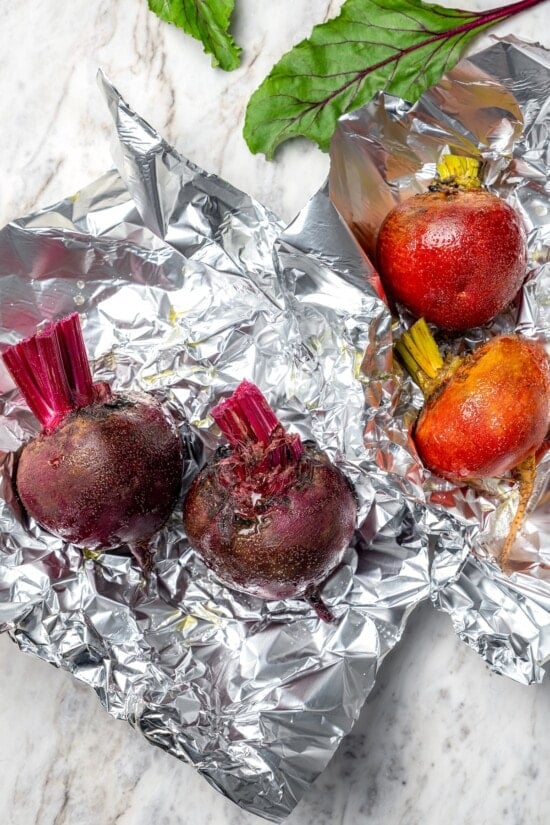 Red beets and golden beets each on separate sheets of foil.