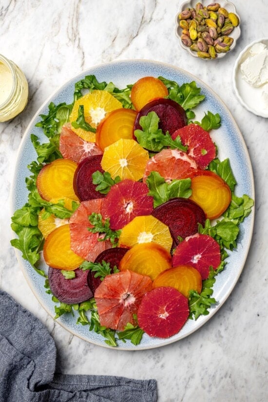 Sliced beets and citrus fruit on platter with arugula.