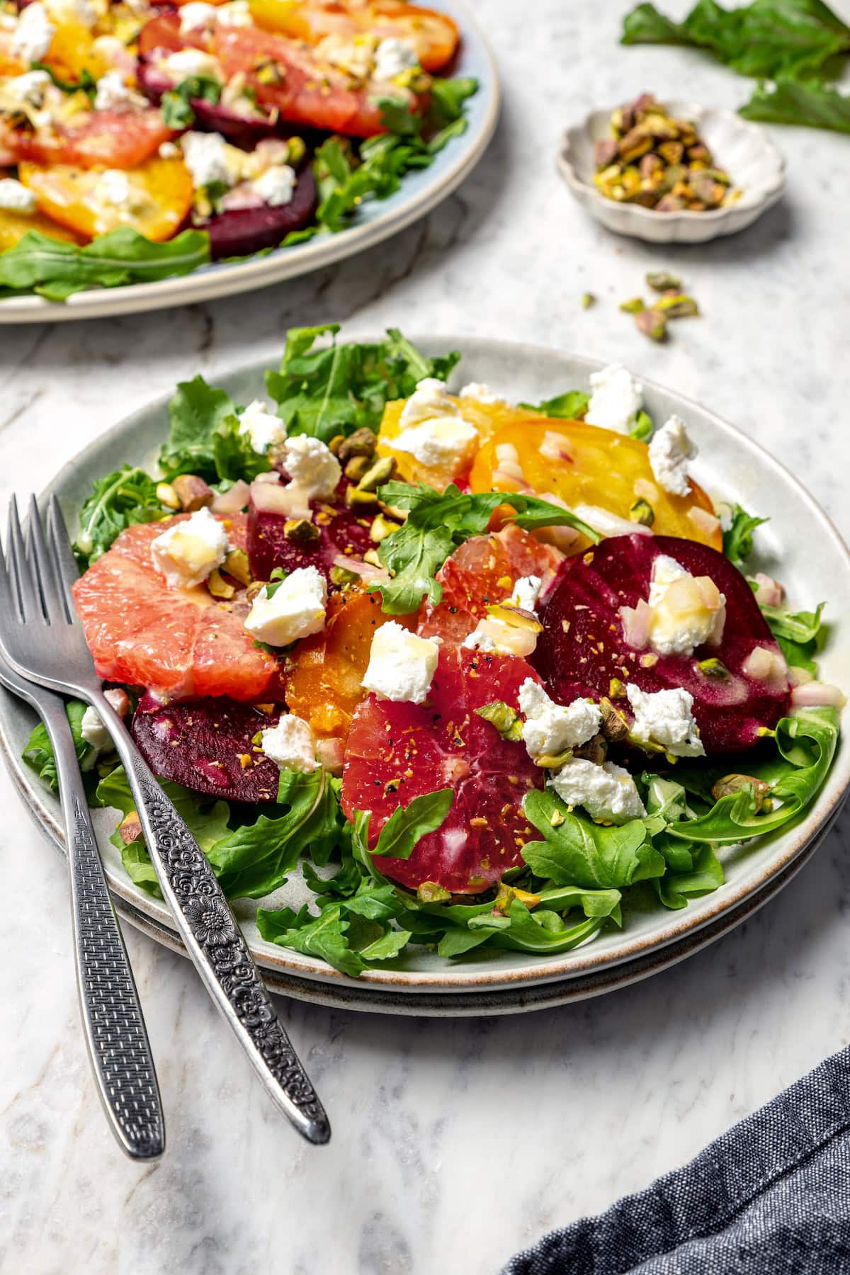 Roasted beet and citrus salad on plate with two forks.