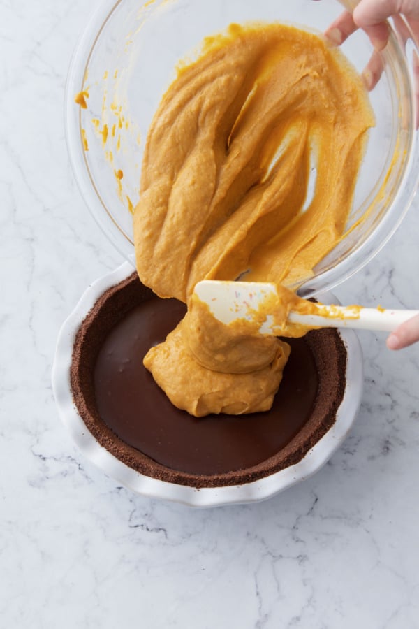 Pouring finished pumpkin cream on top of set ganache.