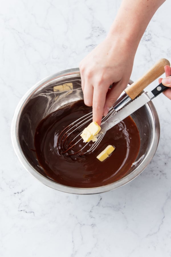Adding small cubes of butter to the ganache.
