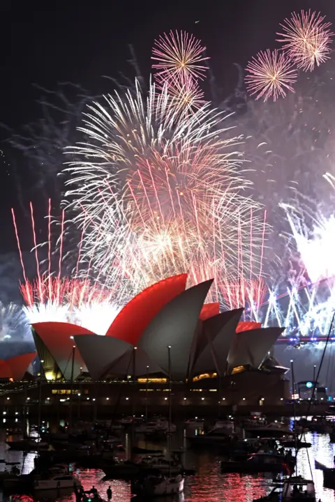 AFP via Getty Images Fireworks lit up the midnight sky over Sydney Harbour Bridge and Sydney Opera House during New Year's Day celebrations in Australia