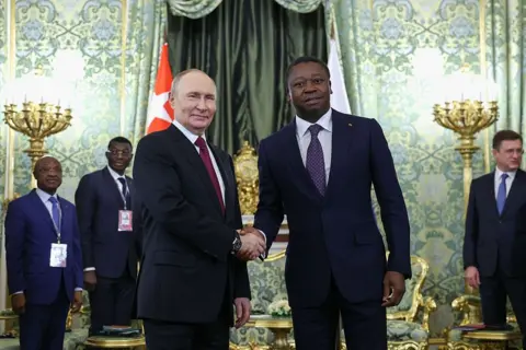 AFP via Getty Images Russia's President Vladimir Putin and Togo's President of the Council of Ministers Faure Gnassingbé shake hands as they meet at the Kremlin in Moscow.