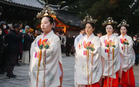 AFP via Getty Images In Osaka, Japan, four young women dressed in traditional kimono take part in a Shinto ritual procession to mark the end of the year at Sumiyoshi Taisha, one of Japan's oldest Shinto shrines.