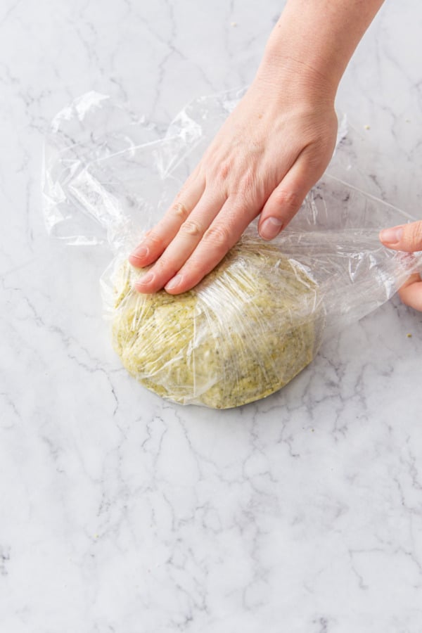 Wrapping pistachio crust in plastic wrap before refrigerating.